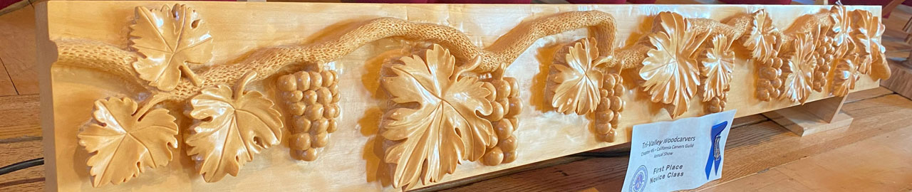 Wood carved door panel featuring carved vine with leafs and grapes.