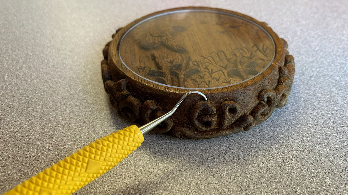 Undercutting the ornamental border with a dental tool.