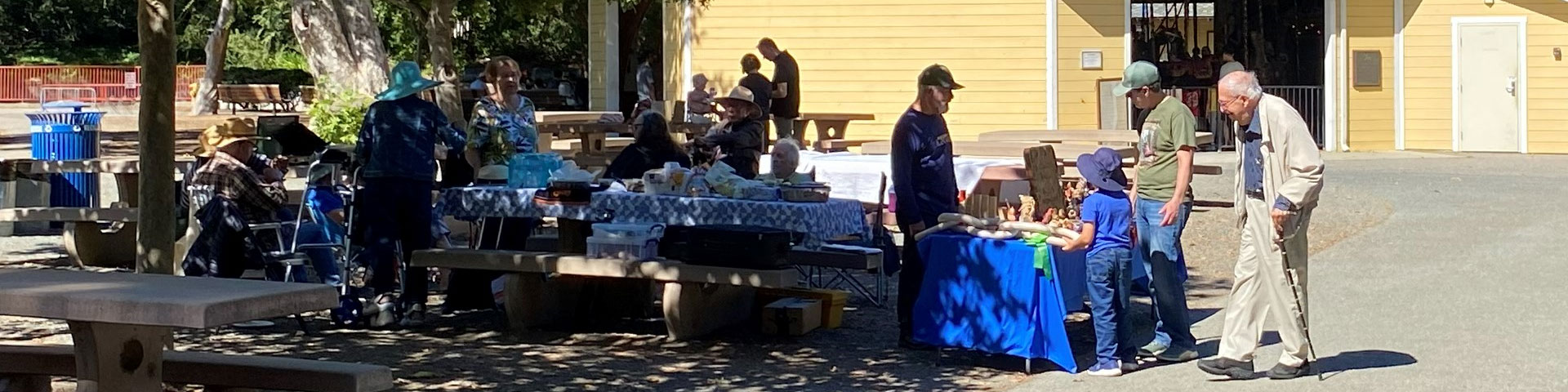 At the woodcarving picnic, members enjoy chatting, and Dan Brady explains woodcarving to the visitors.