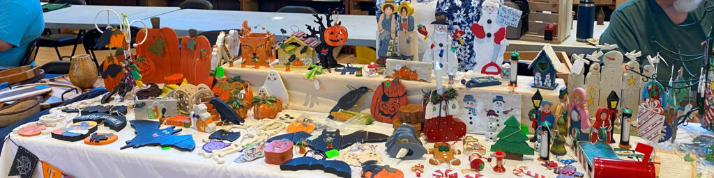 A table filled with colorful ornaments painted by Jerry Jensen.