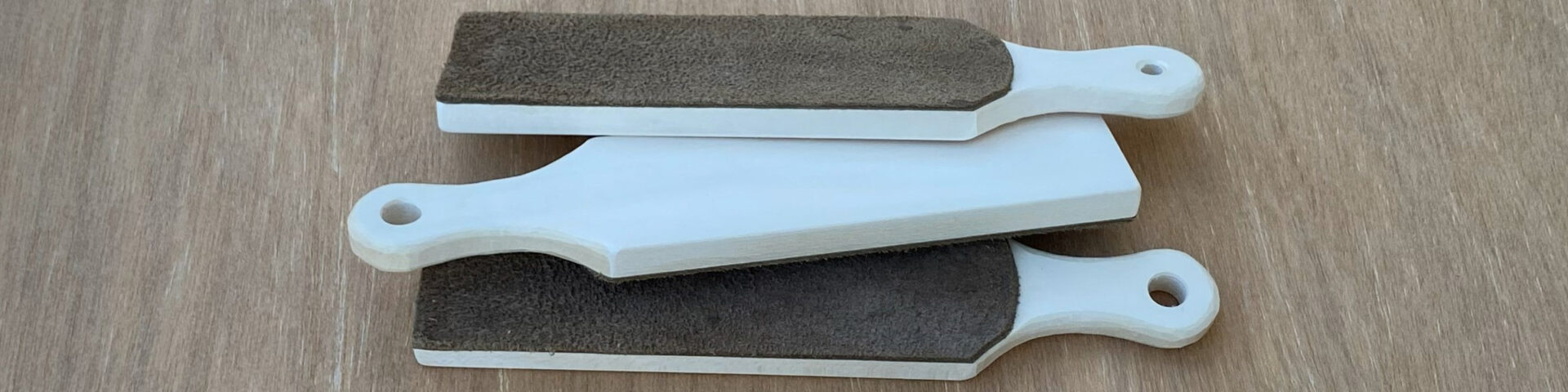 Three strops with whittled handles made by Roman Chernikov.