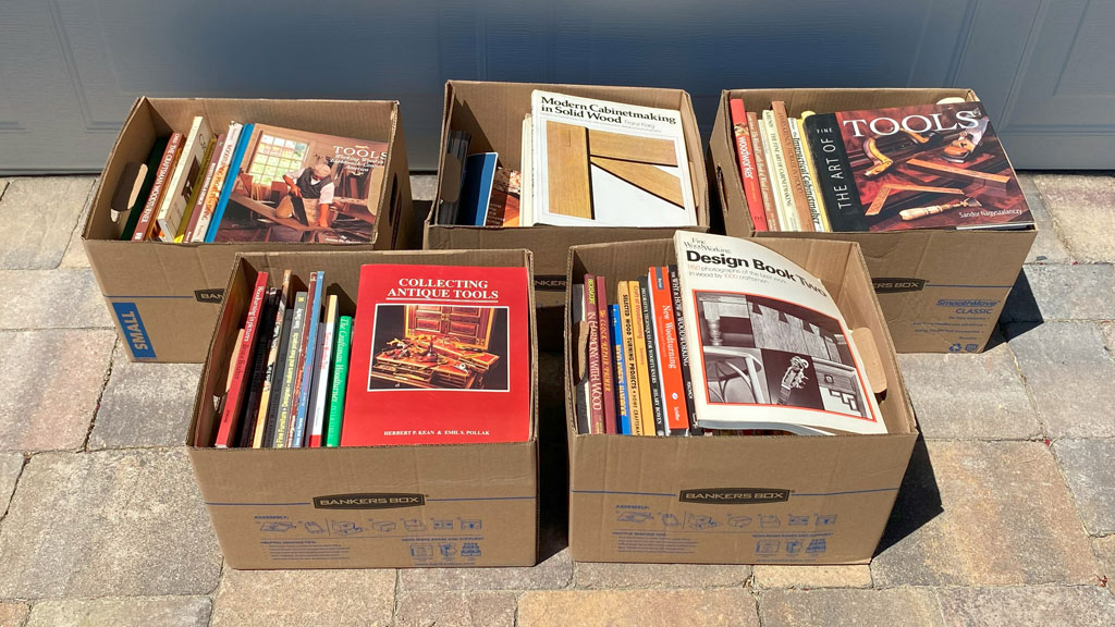 Five cardboard boxes full of woodworking tools.